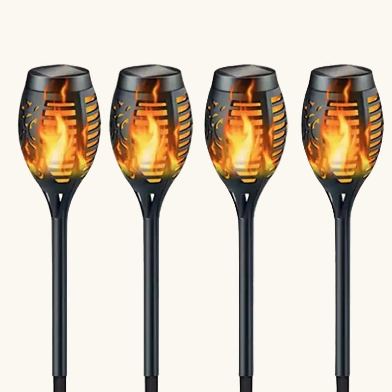 Four solar garden lights with flame design on a white background